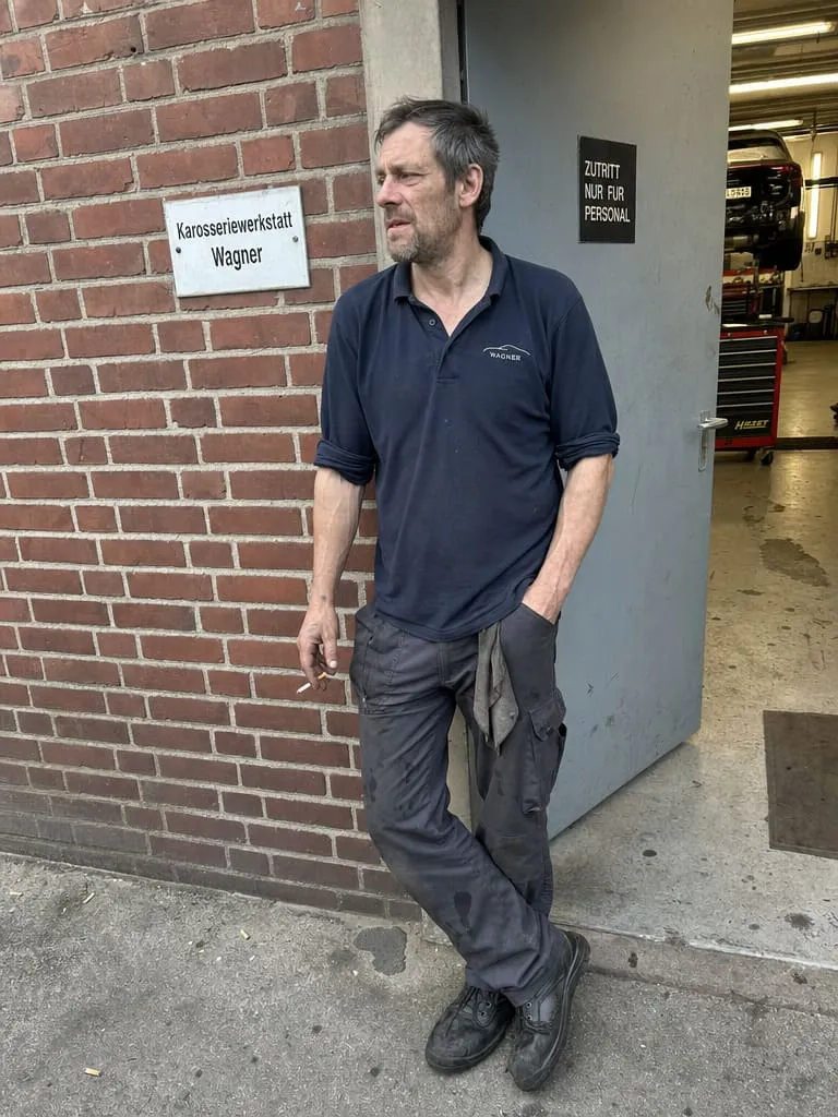 Karosseriebauer vor der Werkstatt